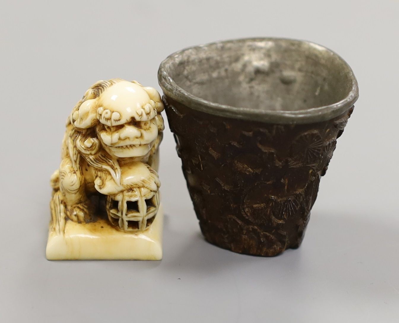 A Chinese or Japanese ivory lion dog 18th/19th century and a Chinese carved nut cup, 19th century. 4cm